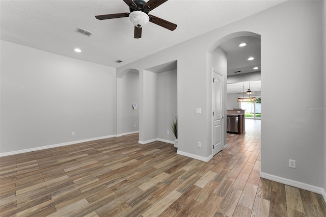 6539 Chagford Ln, Windermere, FL 34786 - spare room featuring arched walkways, a ceiling fan, light wood-style floors, recessed lighting, and a textured ceiling