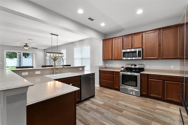 6539 Chagford Ln, Windermere, FL 34786 - kitchen featuring appliances with stainless steel finishes, light wood-style flooring, a ceiling fan, recessed lighting, and light stone counters