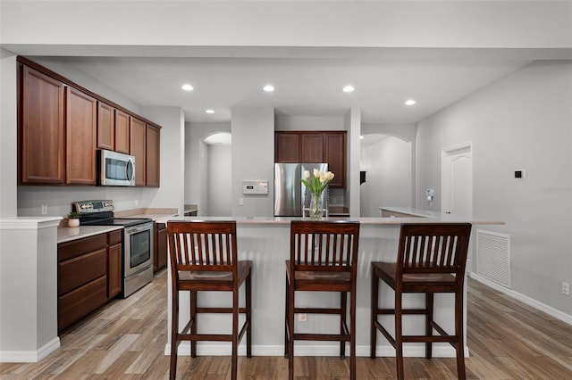 6539 Chagford Ln, Windermere, FL 34786 - kitchen with appliances with stainless steel finishes, arched walkways, light wood finished floors, and recessed lighting