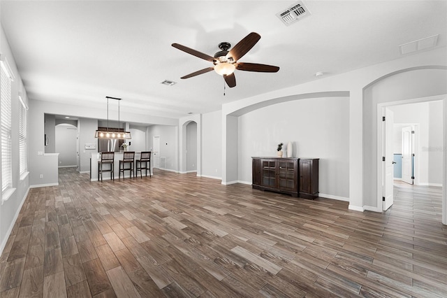 6539 Chagford Ln, Windermere, FL 34786 - unfurnished living room featuring arched walkways, ceiling fan, and dark wood-type flooring