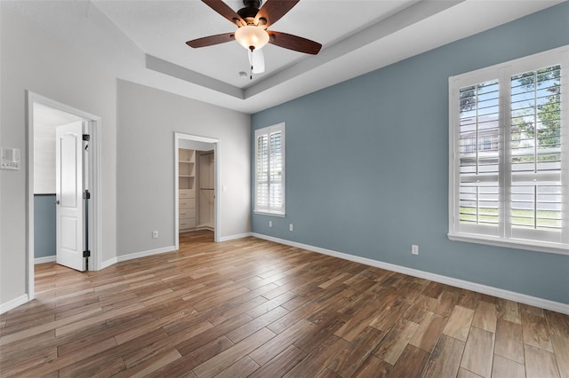6539 Chagford Ln, Windermere, FL 34786 - unfurnished bedroom with multiple windows, a walk in closet, and wood finished floors