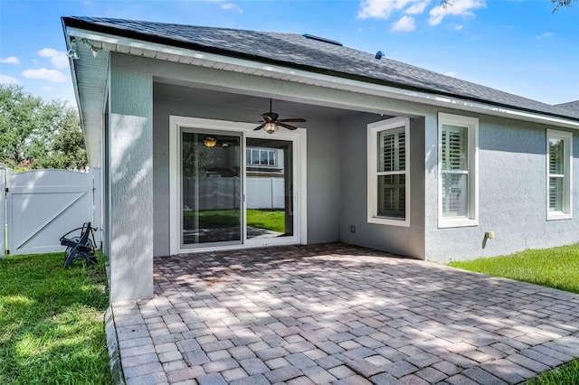 6539 Chagford Ln, Windermere, FL 34786 - entrance to property with a ceiling fan, a patio area, stucco siding, and a gate