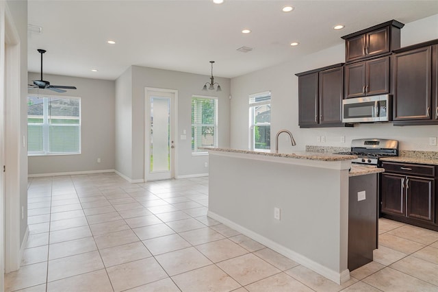 11307 Grand Park Ave, Riverview, FL 33578 - kitchen with stainless steel appliances, recessed lighting, healthy amount of natural light, light tile patterned floors, and dark brown cabinets