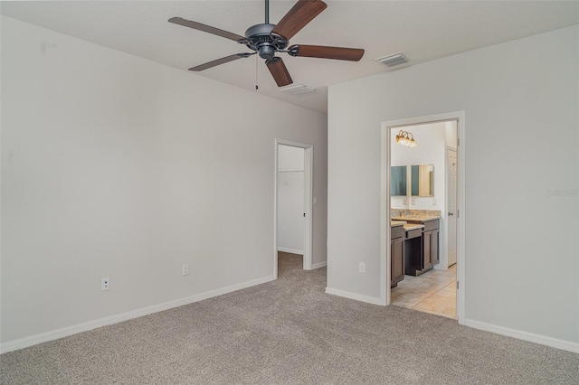 11307 Grand Park Ave, Riverview, FL 33578 - unfurnished bedroom with light colored carpet, a walk in closet, ensuite bathroom, and ceiling fan