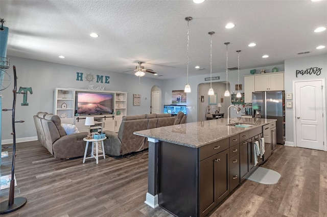 1005 Thunderhead Ln, Minneola, FL 34715 - kitchen featuring stainless steel fridge, arched walkways, dark wood-style flooring, a ceiling fan, and open floor plan
