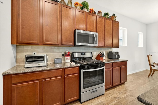 1559 Bayfront Park Aly, Winter Garden, FL 34787 - kitchen featuring stainless steel appliances, decorative backsplash, and brown cabinets
