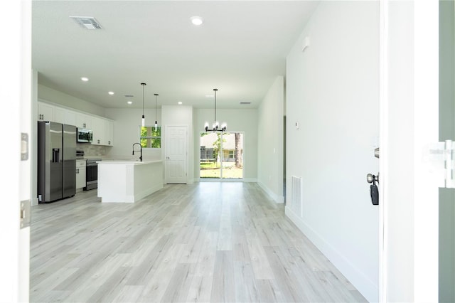 2011 W Tacoma Dr, Citrus Springs, FL 34434 - kitchen featuring stainless steel appliances, a chandelier, light countertops, white cabinets, and light wood-style flooring