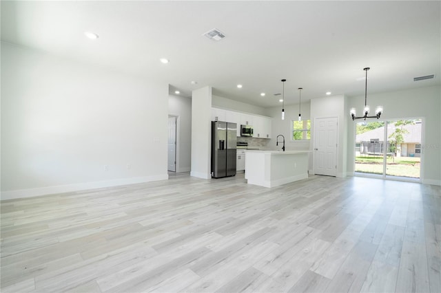 2011 W Tacoma Dr, Citrus Springs, FL 34434 - unfurnished living room with a chandelier, light wood-style floors, and recessed lighting