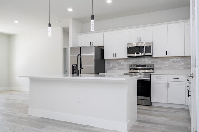 2011 W Tacoma Dr, Citrus Springs, FL 34434 - kitchen with appliances with stainless steel finishes, an island with sink, tasteful backsplash, light countertops, and white cabinets