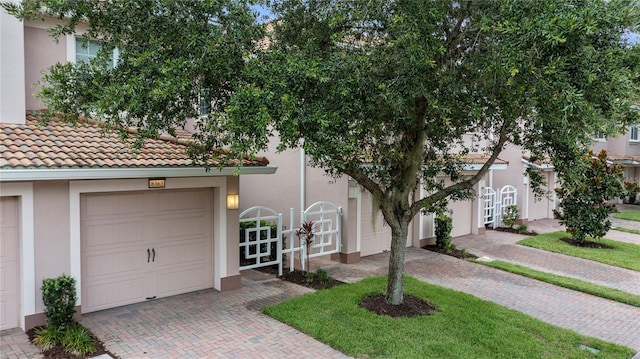 8362 Bella Tierra Ct Unit 10146, Davenport, FL 33896 - view of front facade with stucco siding, decorative driveway, a gate, and a tile roof