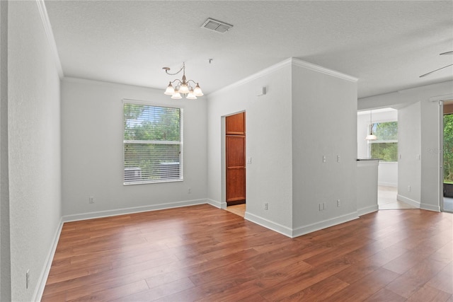 8362 Bella Tierra Ct Unit 10146, Davenport, FL 33896 - spare room featuring a chandelier, hardwood / wood-style flooring, crown molding, and a textured ceiling