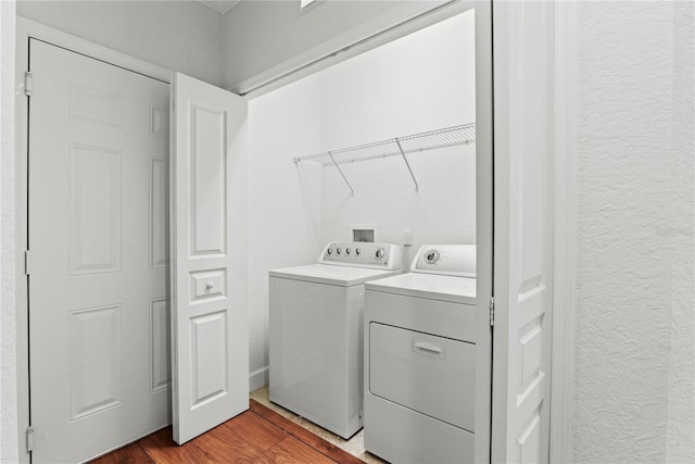 8362 Bella Tierra Ct Unit 10146, Davenport, FL 33896 - laundry area featuring separate washer and dryer, a textured wall, and wood finished floors