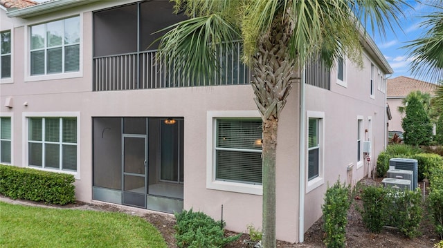 8362 Bella Tierra Ct Unit 10146, Davenport, FL 33896 - rear view of house featuring stucco siding and a sunroom