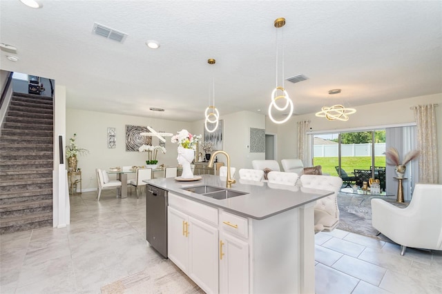 4828 Magnetite Loop, Mount Dora, FL 32757 - kitchen with stainless steel dishwasher, an island with sink, white cabinets, and decorative light fixtures
