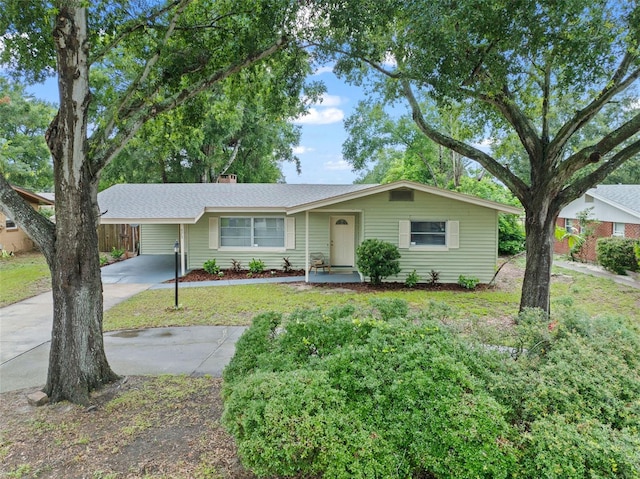 575 Ave M SE, Winter Haven, FL 33880 - single story home featuring concrete driveway, a carport, a front yard, and a chimney