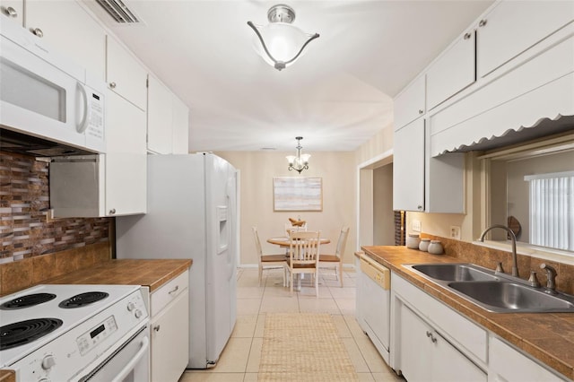 575 Ave M SE, Winter Haven, FL 33880 - kitchen featuring white appliances, white cabinets, tasteful backsplash, a chandelier, and light tile patterned floors