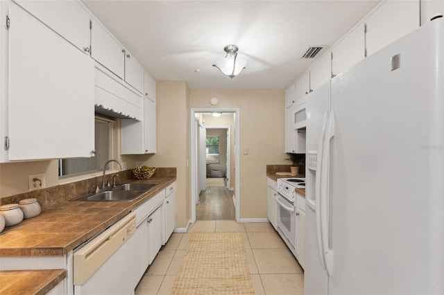 575 Ave M SE, Winter Haven, FL 33880 - kitchen with white appliances, white cabinets, and light tile patterned floors