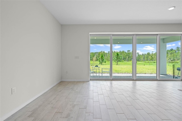 17571 Saw Palmeto Ave, Clermont, FL 34714 - empty room with light wood finished floors, view of scattered trees, and recessed lighting