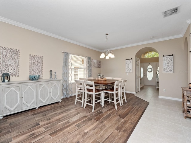 2454 Black Lake Blvd, Winter Garden, FL 34787 - dining room featuring arched walkways, a chandelier, ornamental molding, and light wood finished floors