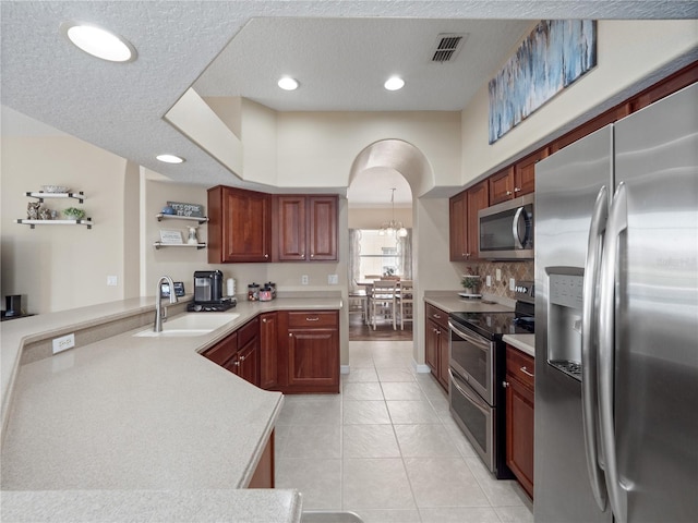 2454 Black Lake Blvd, Winter Garden, FL 34787 - kitchen with stainless steel appliances, light countertops, open shelves, light tile patterned floors, and a peninsula