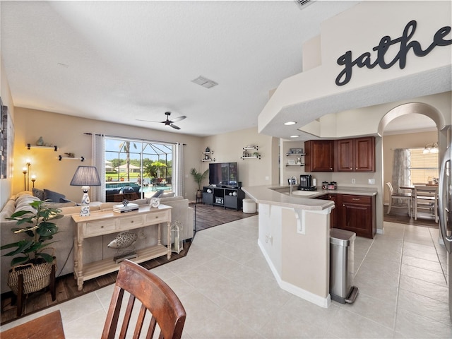 2454 Black Lake Blvd, Winter Garden, FL 34787 - kitchen featuring open floor plan, light countertops, light tile patterned flooring, a breakfast bar, and a ceiling fan