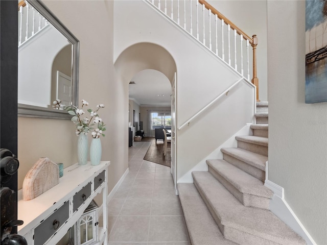 2454 Black Lake Blvd, Winter Garden, FL 34787 - entrance foyer with light tile patterned floors, arched walkways, stairway, and crown molding