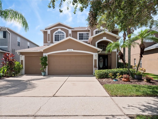 2454 Black Lake Blvd, Winter Garden, FL 34787 - view of front of house with stucco siding, an attached garage, and concrete driveway