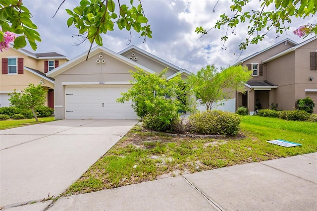 12104 Fawn Brindle St, Riverview, FL 33578 - view of front of house featuring a garage, stucco siding, concrete driveway, and a front lawn
