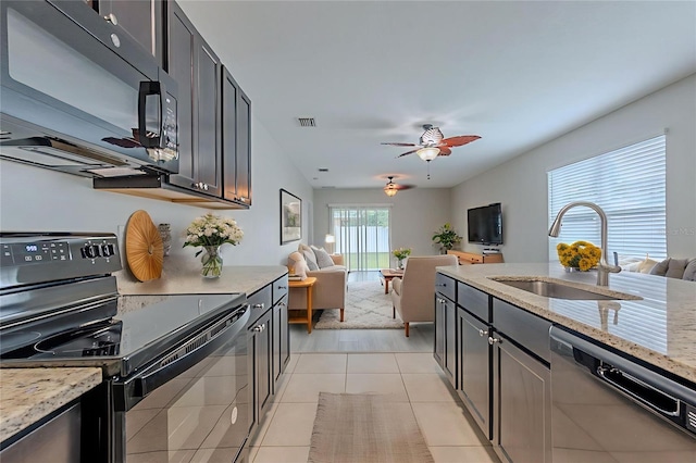 12104 Fawn Brindle St, Riverview, FL 33578 - kitchen featuring black appliances, open floor plan, light stone counters, and a ceiling fan