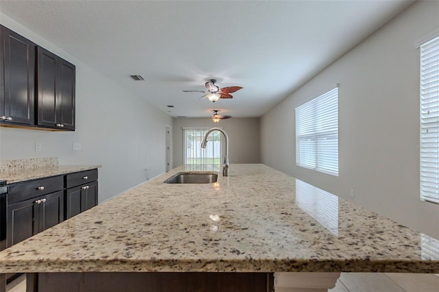 12104 Fawn Brindle St, Riverview, FL 33578 - kitchen featuring a kitchen island with sink, ceiling fan, and light stone counters