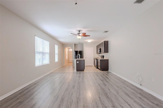 12104 Fawn Brindle St, Riverview, FL 33578 - unfurnished living room featuring arched walkways, ceiling fan, and light wood-style flooring