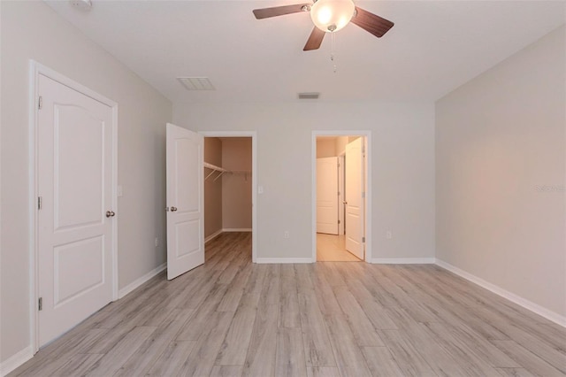 12104 Fawn Brindle St, Riverview, FL 33578 - unfurnished bedroom with light wood-style floors, a spacious closet, and a ceiling fan