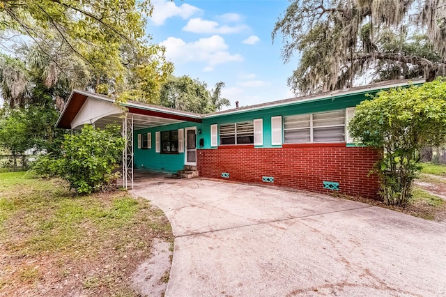 770 W Webster Ave, Winter Park, FL 32789 - view of front of home with concrete driveway, an attached carport, and brick siding