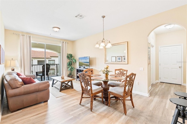 4024 Breakview Dr Unit 402, Orlando, FL 32819 - dining area with arched walkways, light wood-type flooring, and a chandelier