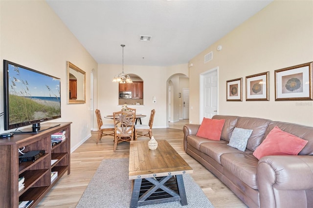 4024 Breakview Dr Unit 402, Orlando, FL 32819 - living room featuring arched walkways, light wood-style flooring, and a chandelier