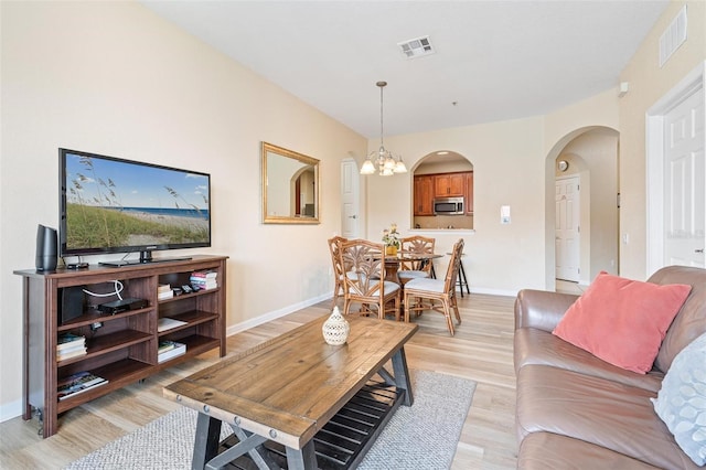 4024 Breakview Dr Unit 402, Orlando, FL 32819 - living area featuring light wood-type flooring, arched walkways, and a chandelier