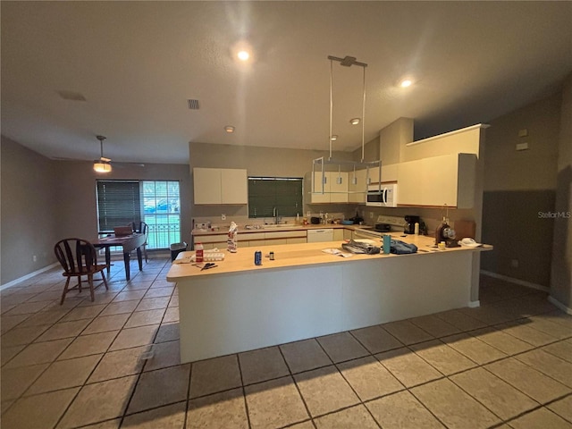 131 49th Ct E, Palmetto, FL 34221 - kitchen with white appliances, white cabinetry, light countertops, light tile patterned floors, and vaulted ceiling
