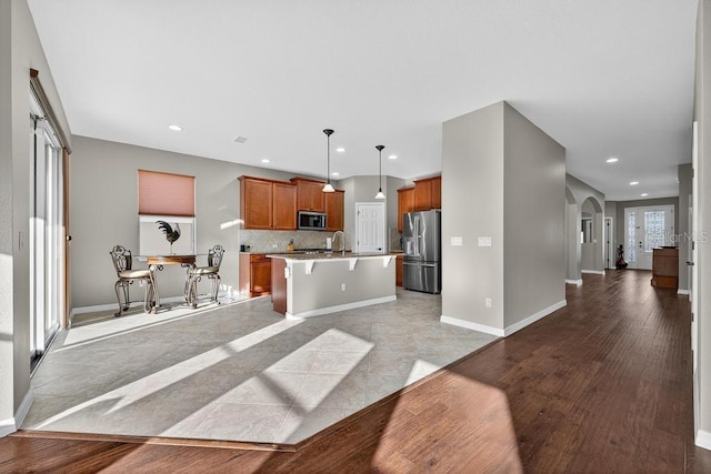30120 Hackney Loop, Mount Dora, FL 32757 - kitchen featuring stainless steel appliances, open floor plan, arched walkways, light countertops, and recessed lighting