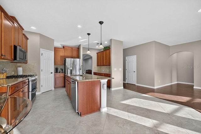 30120 Hackney Loop, Mount Dora, FL 32757 - kitchen with arched walkways, appliances with stainless steel finishes, light stone countertops, tasteful backsplash, and recessed lighting