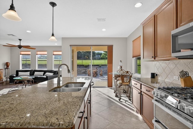 30120 Hackney Loop, Mount Dora, FL 32757 - kitchen featuring appliances with stainless steel finishes, tasteful backsplash, recessed lighting, pendant lighting, and brown cabinetry
