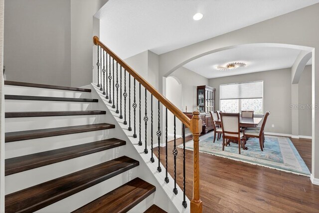 30120 Hackney Loop, Mount Dora, FL 32757 - stairway featuring arched walkways, wood finished floors, and recessed lighting