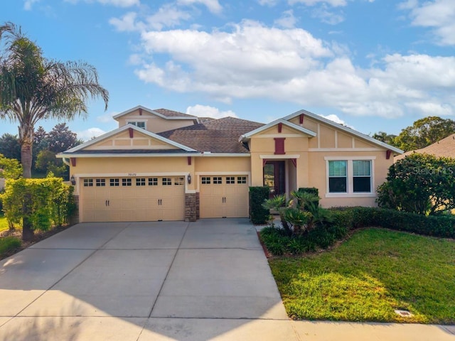 30120 Hackney Loop, Mount Dora, FL 32757 - craftsman house featuring a garage, concrete driveway, stucco siding, a front lawn, and stone siding