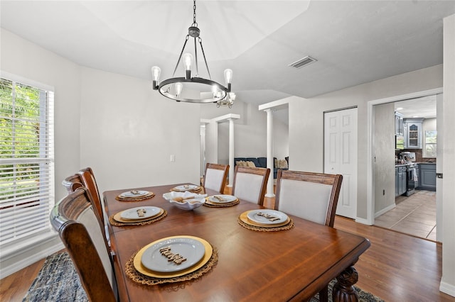 5949 Broken Bow Ln, Port Orange, FL 32127 - dining area with a chandelier, light wood-style flooring, and decorative columns