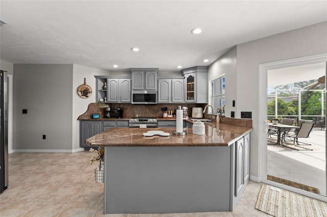 5949 Broken Bow Ln, Port Orange, FL 32127 - kitchen with gray cabinets, stainless steel appliances, open shelves, a peninsula, and tasteful backsplash