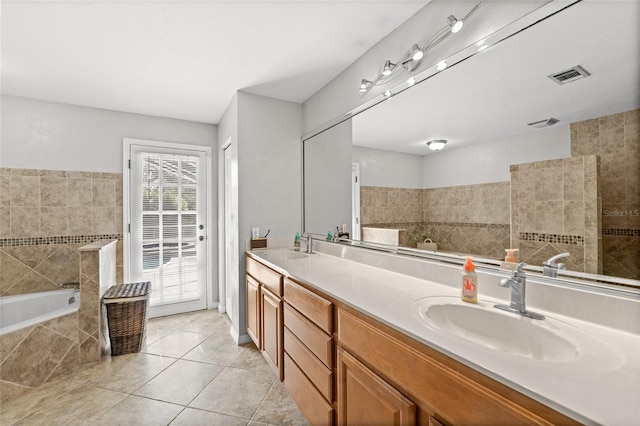 5949 Broken Bow Ln, Port Orange, FL 32127 - bathroom with a garden tub, double vanity, tile patterned floors, and tile walls