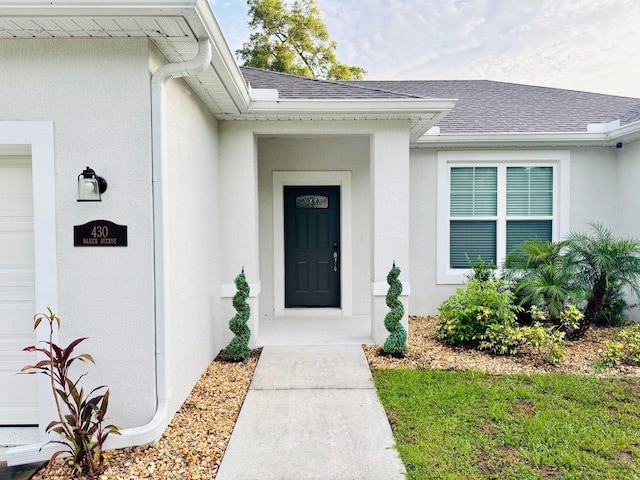 430 Baker Ave, Lake Helen, FL 32744 - entrance to property featuring a shingled roof, stucco siding, and a garage