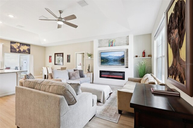 430 Baker Ave, Lake Helen, FL 32744 - living area featuring a raised ceiling, light wood-style floors, a ceiling fan, recessed lighting, and a glass covered fireplace