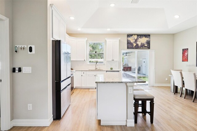 430 Baker Ave, Lake Helen, FL 32744 - kitchen with freestanding refrigerator, a tray ceiling, light wood-style floors, and recessed lighting