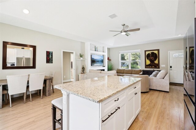 430 Baker Ave, Lake Helen, FL 32744 - kitchen with ceiling fan, stainless steel fridge, light wood-style flooring, a center island, and white cabinets