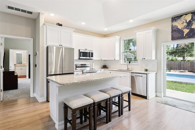 430 Baker Ave, Lake Helen, FL 32744 - kitchen with stainless steel appliances, light wood-type flooring, white cabinets, decorative backsplash, and recessed lighting